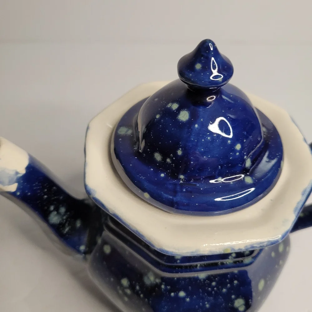 A blue and white speckled teapot. 271